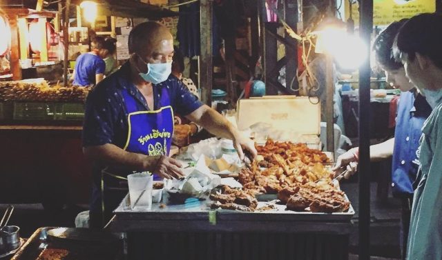 Thai man serving fried chicken